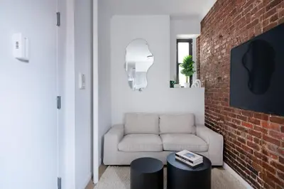 a living room with a couch and a brick wall at 153-1G Newly Renovated 2BR Lower East Side in New York