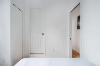 a bedroom with white walls and a white bed at 153-1G Newly Renovated 2BR Lower East Side in New York