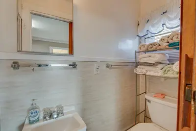 a bathroom with a sink and a toilet and a mirror at Cozy Pennsylvania Home with Fire Pit and Dock Access! in Carbondale