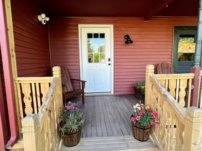 a porch of a house with two baskets of flowers at 2 Bed Berkshire Getaway @ Stephentown Hotel in Stephentown
