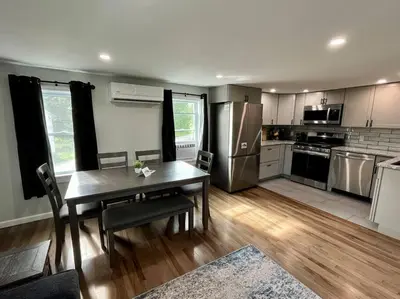 a kitchen with a table and a kitchen with stainless steel appliances at 2 Bed Berkshire Getaway @ Stephentown Hotel in Stephentown