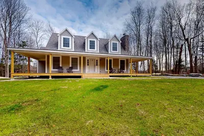a house with a large yard with a green field at Modern Mountain Homestead in Dover