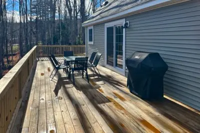 a deck with a table and chairs and a grill at Modern Mountain Homestead in Dover
