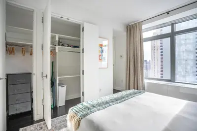 a bedroom with a bed and a large window at Financial District 1br w WD gym elevator NYC-1378 in New York