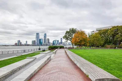 a walkway in a park with a view of the city at FiDi jr 1br w game room resident-only bar NYC-1336 in New York