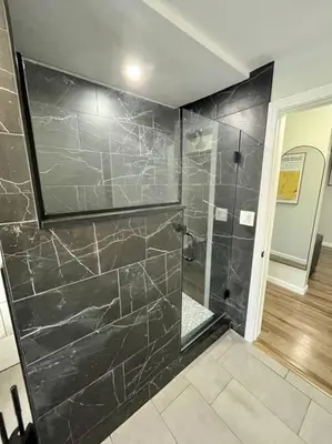 a bathroom with a shower with black marble walls at 5 Bed / 3 bath Apt Near Jiminy Peak Berkshires in Stephentown