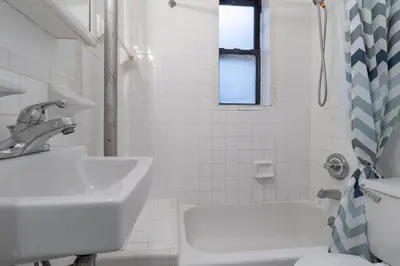 a white bathroom with a sink and a toilet at The Upper East Side Monthly Rentals Apartments in New York