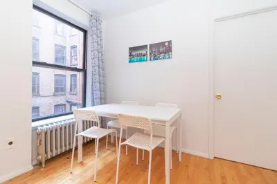 a white table and chairs in a room with a window at The Upper East Side Monthly Rentals Apartments in New York