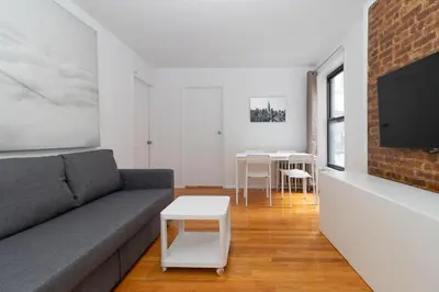 a living room with a couch and a tv at The Upper East Side Monthly Rentals Apartments in New York