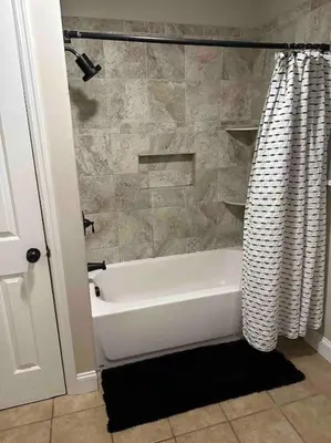 a bathroom with a white tub and a shower curtain at The Gray Horse in Saratoga Springs