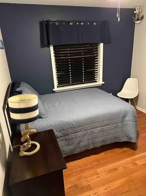 a bedroom with a bed with a window and a table at The Gray Horse in Saratoga Springs