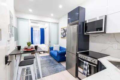 a kitchen with a refrigerator and a table in a room at 317-1AN - New Modern 1BR W&D Walk to Central Park in New York