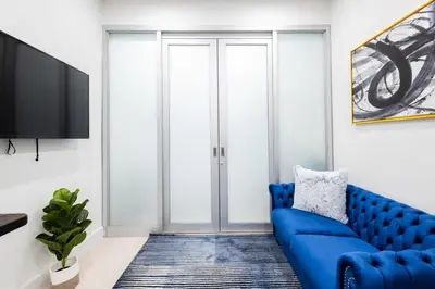 a living room with a blue couch and a tv at 317-1AN - New Modern 1BR W&D Walk to Central Park in New York