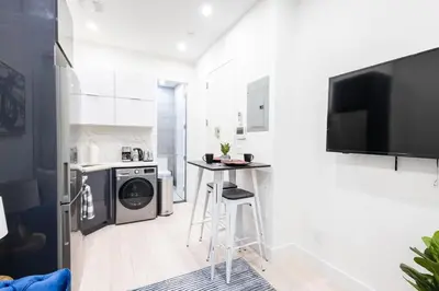 a kitchen with a stove and a table in a room at 317-1AN - New Modern 1BR W&D Walk to Central Park in New York