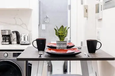 a table with two cups and a plant on it at 317-1AN - New Modern 1BR W&D Walk to Central Park in New York