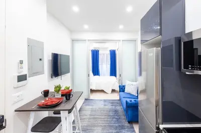 a living room with a blue couch and a table at 317-1AN - New Modern 1BR W&D Walk to Central Park in New York