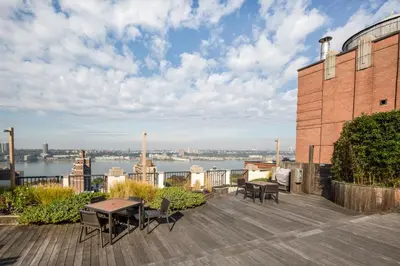 a patio with tables and chairs on top of a building at Upper West Side 2br w rooftop gym nr park NYC-1216 in New York