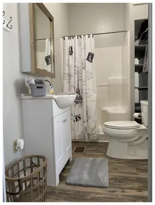 a white bathroom with a toilet and a shower curtain at 2 BR Loft - Walk to Cafes-Breweries- Arts & Entertainment District in Glens Falls