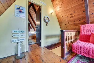 a living room with a red couch and a wooden ceiling at Walk to Ski Lift! Charming Hunter A-Frame in Lanesville