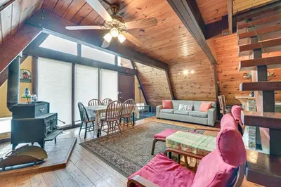 a living room with a ceiling fan and a table at Walk to Ski Lift! Charming Hunter A-Frame in Lanesville