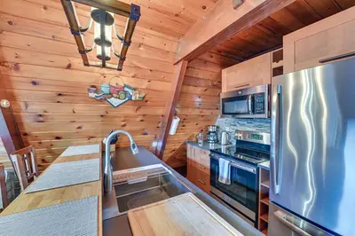 a kitchen with a stove and a refrigerator at Walk to Ski Lift! Charming Hunter A-Frame in Lanesville