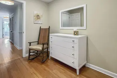 a bedroom with a dresser and a chair and a mirror at Luke's Landing in Westport
