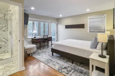 a bedroom with a bed and a desk and a bathroom at Luke's Landing in Westport