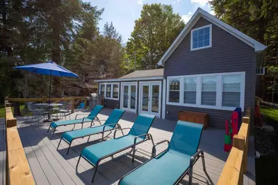 a deck with chairs and a table and an umbrella at Rocky Point #1 in Hamilton