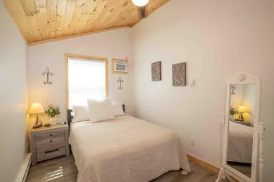 a bedroom with a bed and a mirror in it at Rocky Point #1 in Hamilton