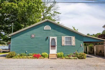 a blue house with a white door and flowers at Hamilton Home #4 in Hamilton