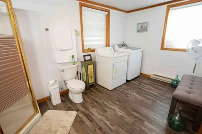 a bathroom with a toilet and a washer and dryer at Hamilton Home #4 in Hamilton