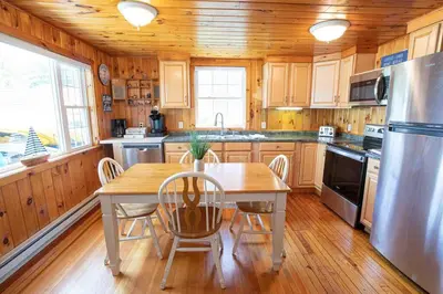 a kitchen with a table and chairs and a refrigerator at Hamilton Home #4 in Hamilton