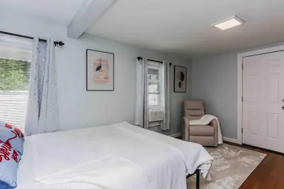 a bedroom with a white bed and a chair at Two Bedroom Apartment on Forestville Bristol in Bristol