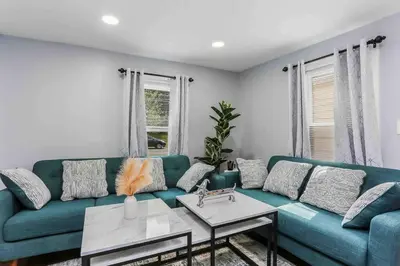a living room with a blue couch and a table at Two Bedroom Apartment on Forestville Bristol in Bristol