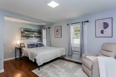 a bedroom with a bed and a chair at Two Bedroom Apartment on Forestville Bristol in Bristol
