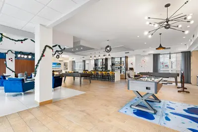 a large room with tables and chairs in a building at Modern 2BR 2BA Condo Sleeps 8 with Gym Laundry 20 Min to NYC in Jersey City