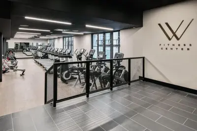 a gym with rows of treadmills and ellipticals at FiDi 1br w game room resident-only speakeasy NYC-1346 in New York
