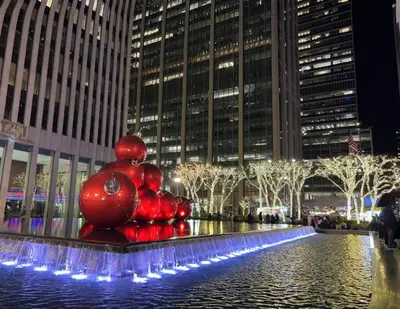 a sculpture of apples in a fountain in a city at moon lotus abode(\u6708\u84ee\u5c45) in New York