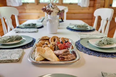 a table topped with a tray of bread and pastries at Comfy Log Cabin Family & Pet Kind by State & Waterparks! in Tobyhanna