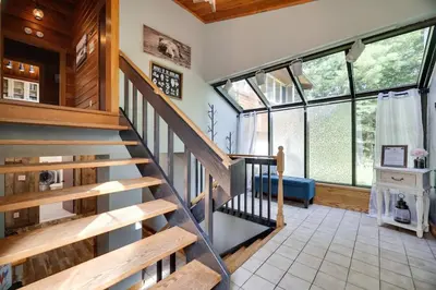 a spiral staircase in a room with large windows at Comfy Log Cabin Family & Pet Kind by State & Waterparks! in Tobyhanna