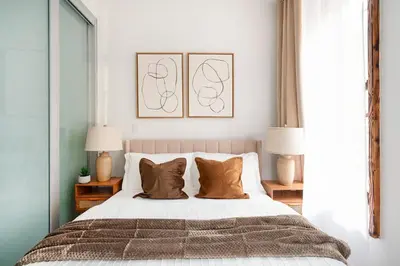 a bedroom with a large bed with two lamps at 317-2A Sleek Modern 1Br UES W D in New York