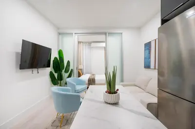 a living room with a table and chairs and a tv at 317-2A Sleek Modern 1Br UES W D in New York