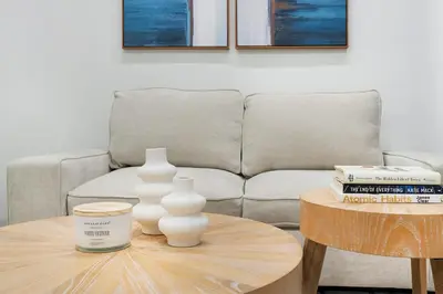 a living room with a couch and a table with vases at 317-2A Sleek Modern 1Br UES W D in New York