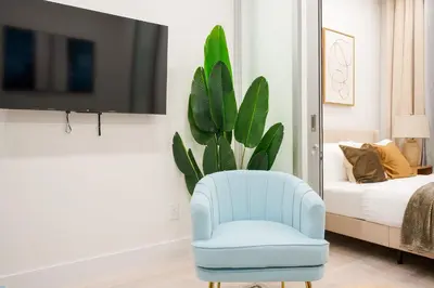 a living room with a blue chair and a plant at 317-2A Sleek Modern 1Br UES W D in New York