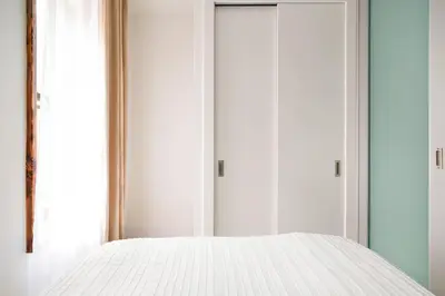 a bedroom with a white bed and two closets at 317-2A Sleek Modern 1Br UES W D in New York