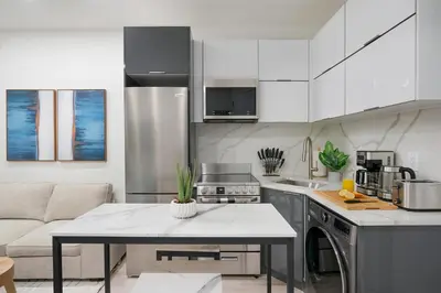 a kitchen with a couch and a table in a room at 317-2A Sleek Modern 1Br UES W D in New York