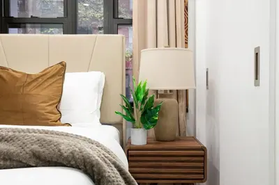 a bedroom with a bed with a lamp and a plant at 317-1B Modern 1Br UES W D in New York
