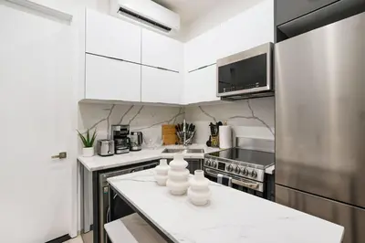 a kitchen with white cabinets and a white counter top at 317-1B Modern 1Br UES W D in New York