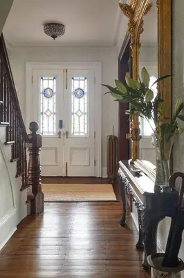 a hallway with a staircase and two stained glass doors at The Kent Collection - The Victorian in Kent