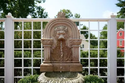 a statue of a lion on a fountain in front of a fence at The Kent Collection - The Victorian in Kent